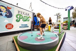 boy plays mini golf at Pixar Putt