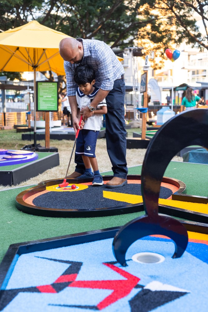 boy and father play mini-golf at Pixar Putt