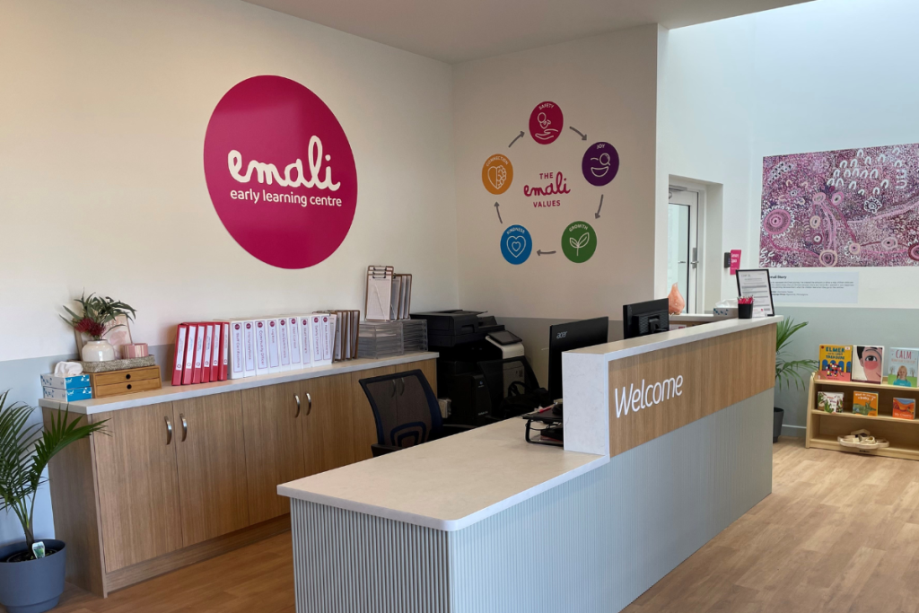 A reception area featuring a large pink sign prominently displayed on the wall, creating a welcoming atmosphere.