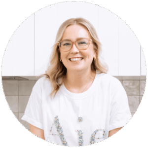 portrait of a smiling woman wearing glasses and white t-shirt in a modern kitchen