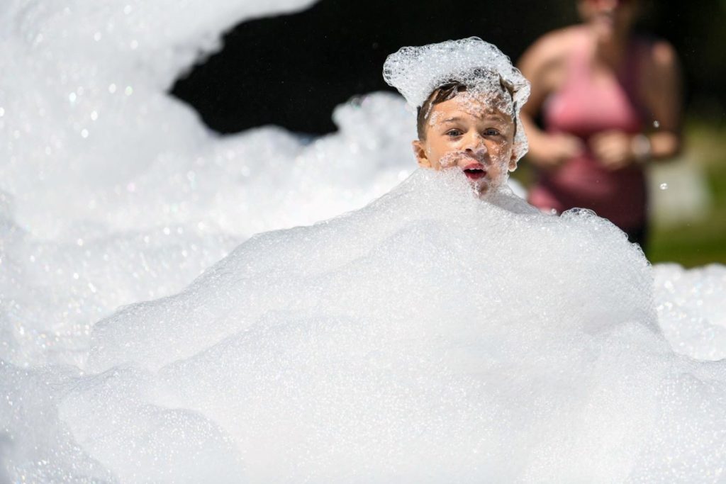 Boy hides in a mountain of foam.