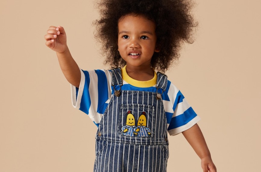 Kid wears Goldie + Ace Bananas in Pyjamas overalls and T-shirt.