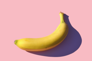 A yellow banana on a pink background.