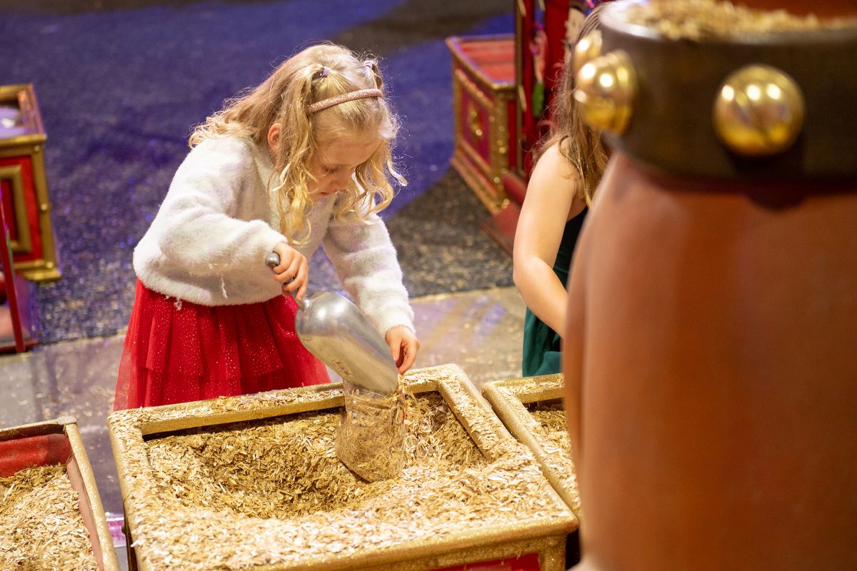 Girl collecting reindeer feed.