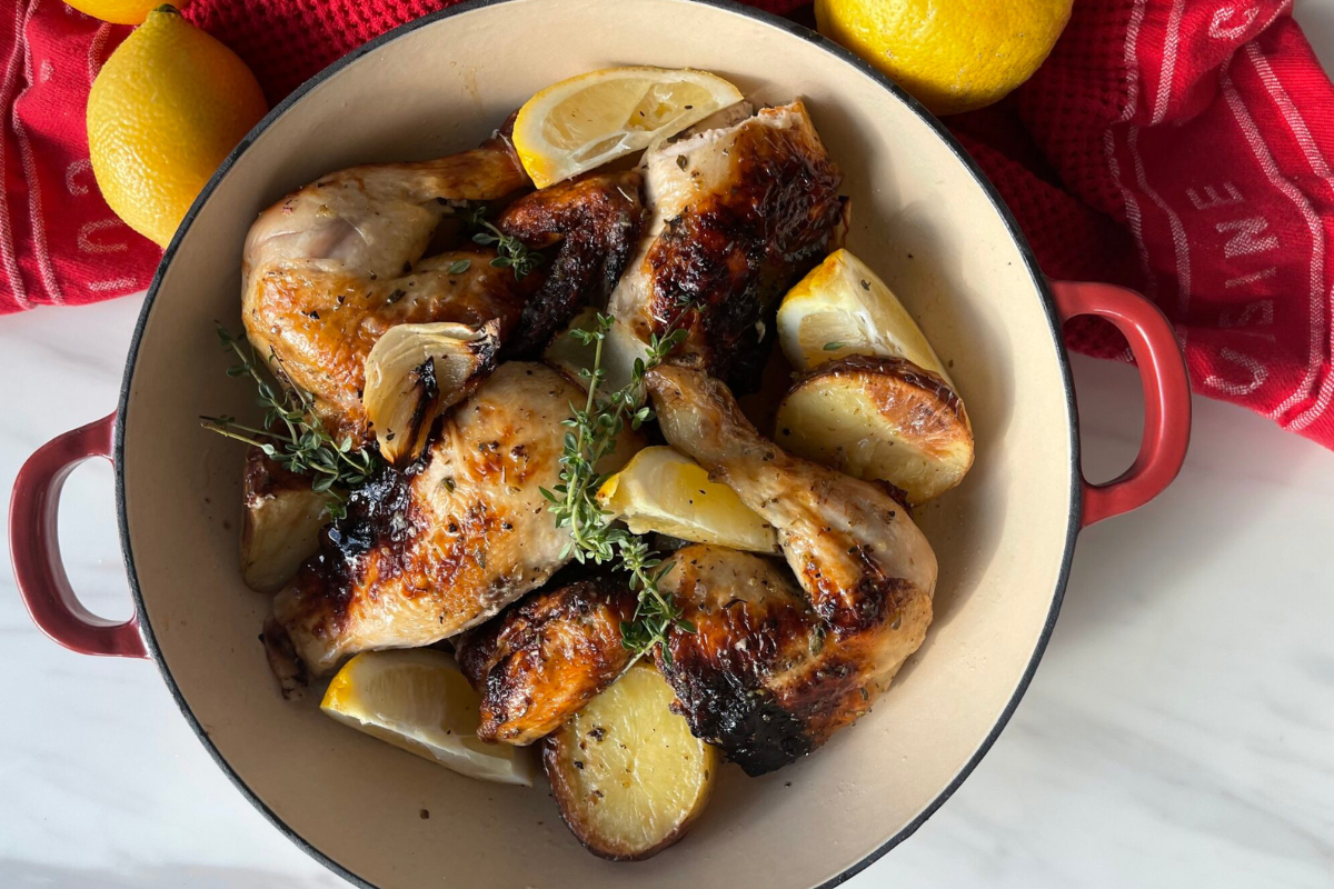 Close-up of chicken dish with roast potatoes and other vegies.