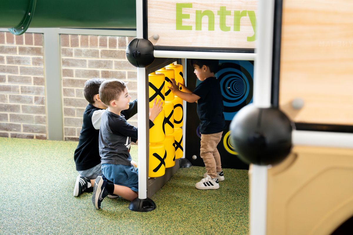  Kids having fun in a vibrant play area, with a clear sign indicating "Enter" nearby.