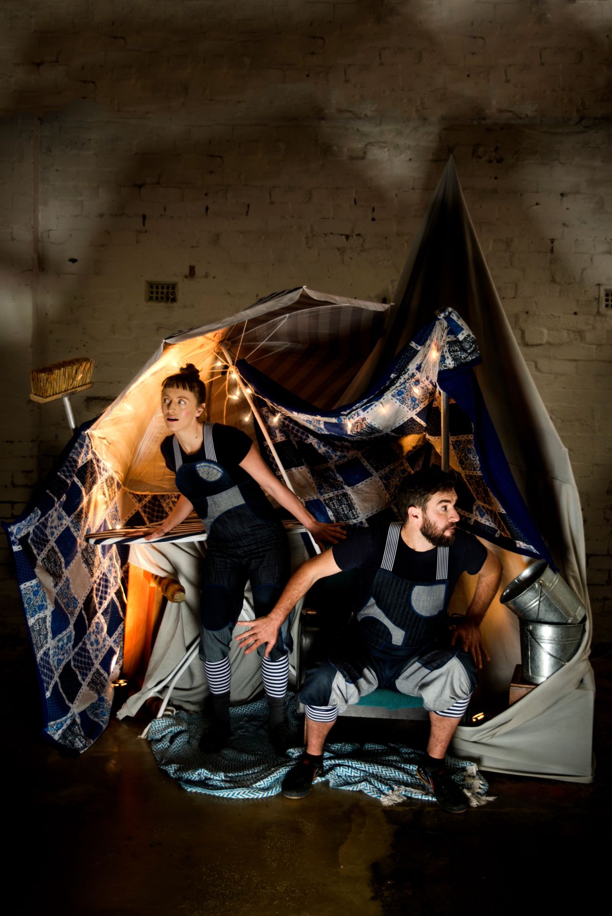 Two people snuggled under a blanket inside a cozy tent, enjoying a moment of warmth and togetherness.