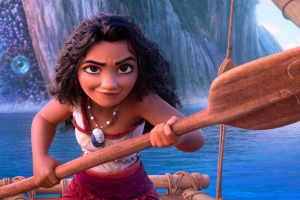 Moana is in the water, holding a paddle.