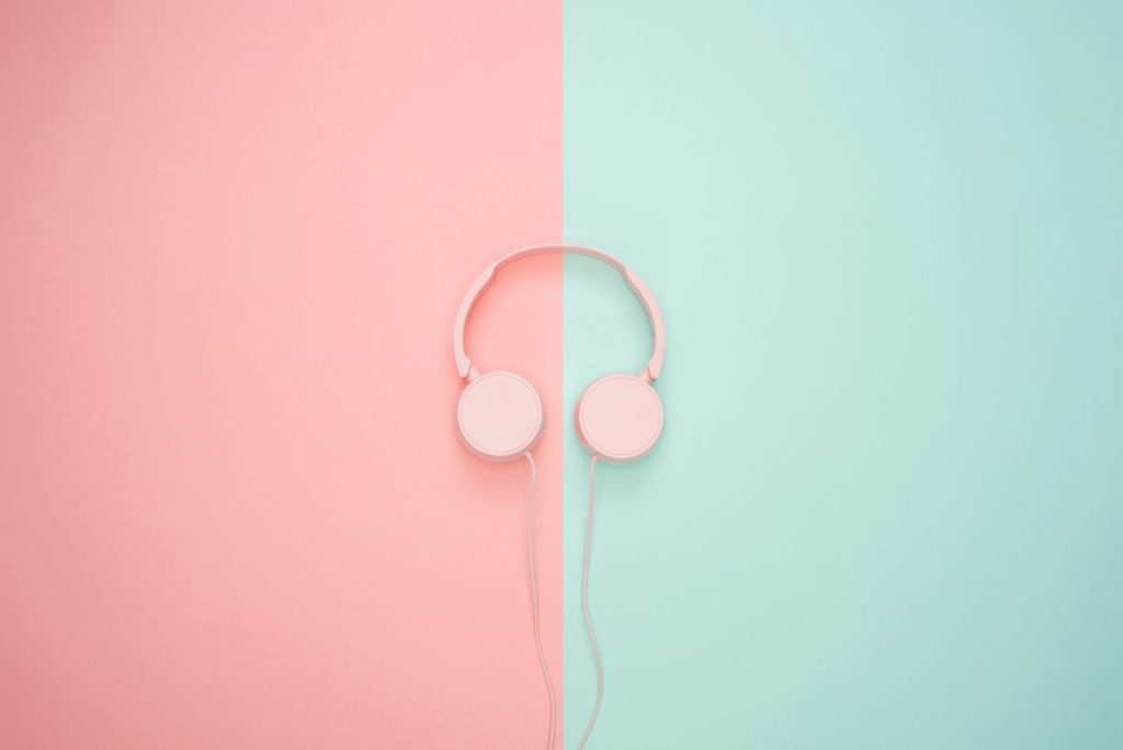 Headphones resting on a vibrant pink and blue background, showcasing a stylish and modern design.