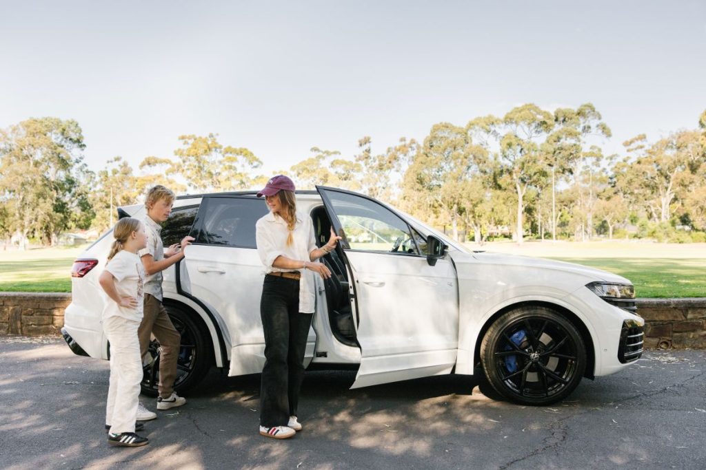 A family of four loading into a white SUV