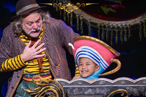 A man and a boy dressed in costumes perform together on stage, showcasing their talent and creativity.