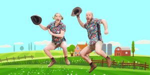 Two farmers in shorts leaping joyfully into the air against a clear blue sky.