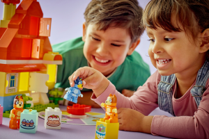 Two children joyfully building with LEGO Friends, surrounded by colorful blocks and imaginative creations.