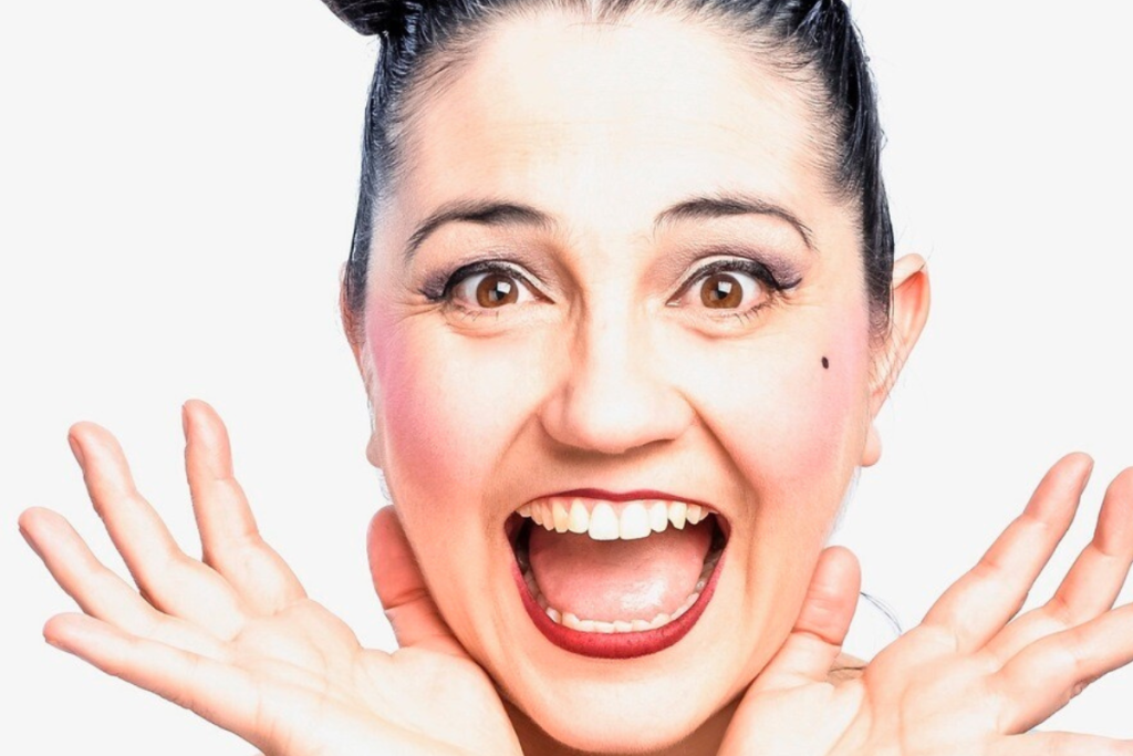 A woman joyfully raises her hands in the air, expressing excitement and freedom.