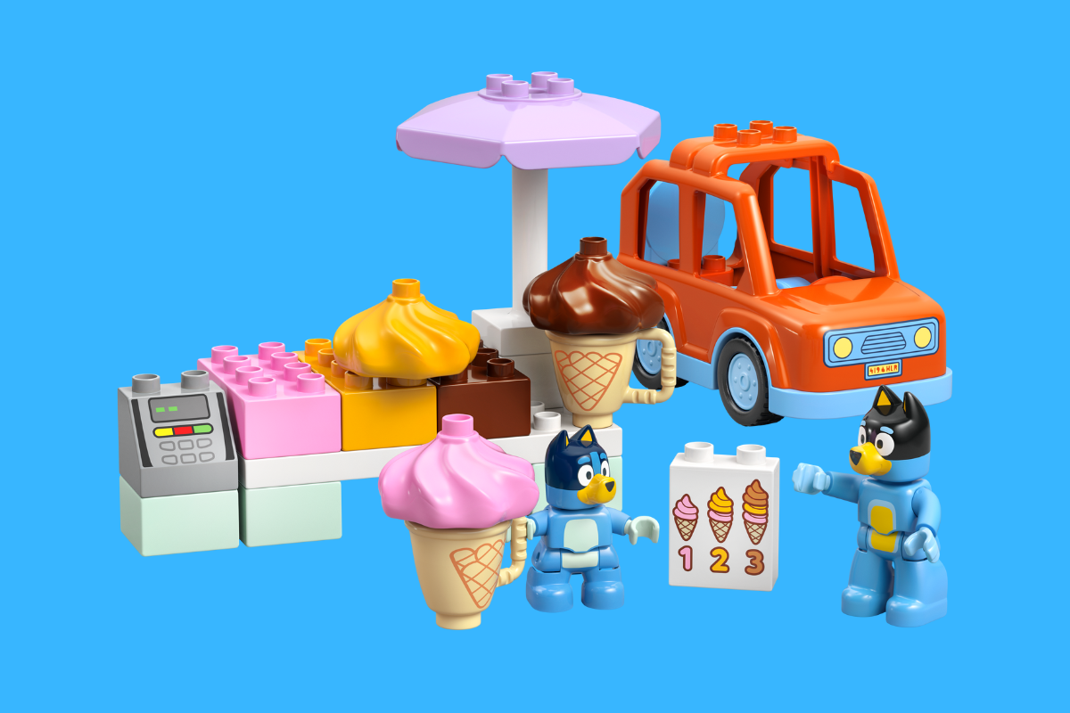 A colorful LEGO ice cream truck with two people enjoying ice cream nearby.