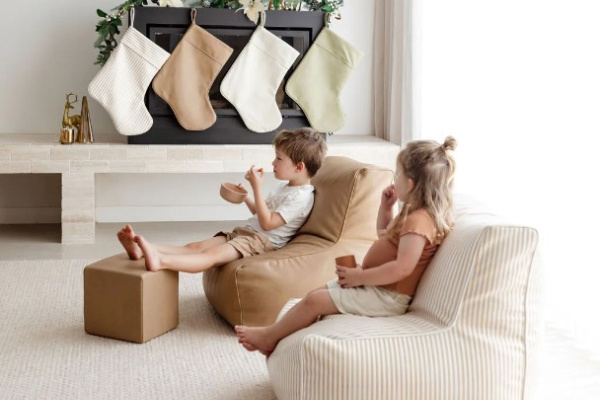  Two children relax on bean bags in front of a cozy fireplace, enjoying a warm and inviting atmosphere.