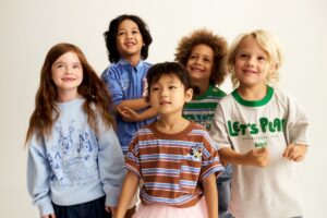 A cheerful group of children standing together wearing Bluey apparel, smiling for the camera.