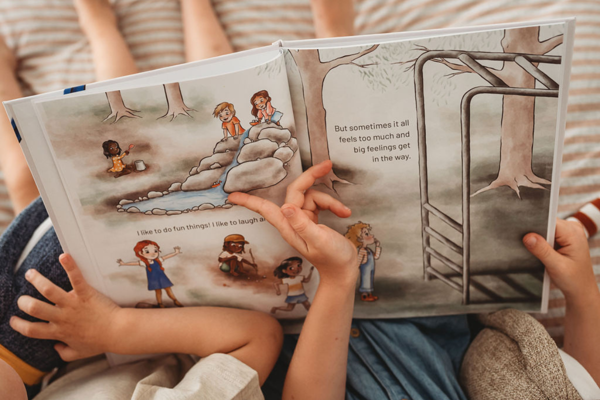 Two children sitting on a bed, engrossed in reading a colorful children's book together.