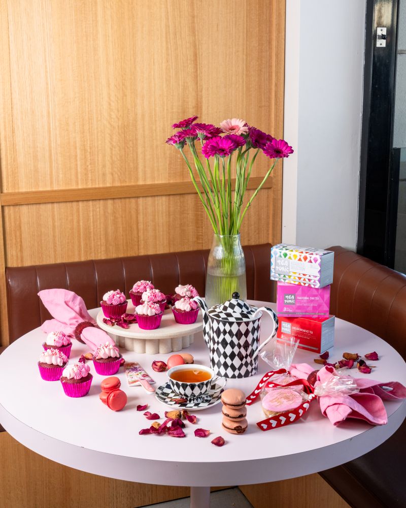 A table adorned with pink and white cupcakes surrounded by fresh flowers.