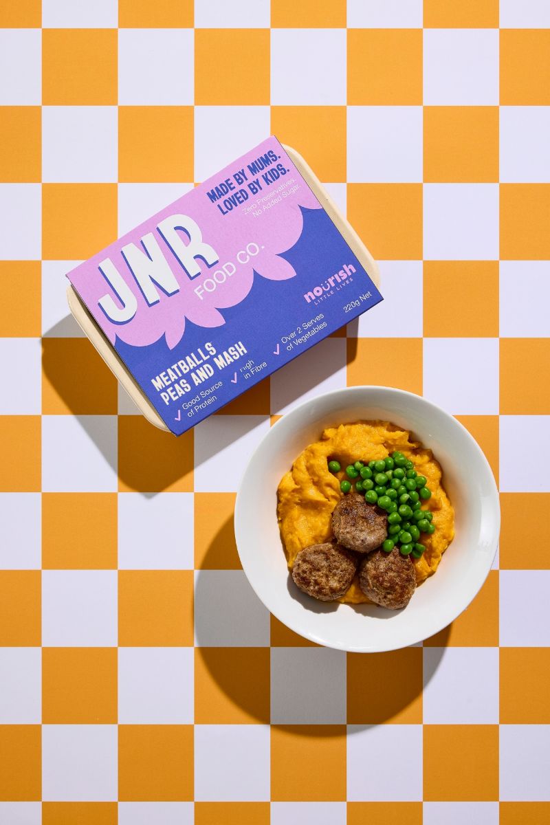 A bowl of food sits next to a box labeled "jnr," suggesting a meal or snack for a child.