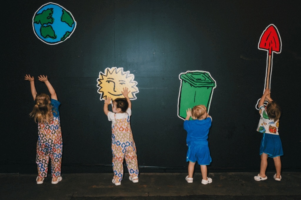 Children joyfully playing with colorful paper cutouts of the Earth, engaging in creative activities together.