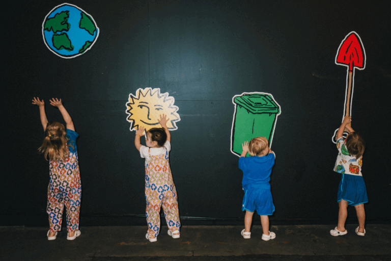 Children joyfully playing with colorful paper cutouts of the Earth, engaging in creative activities together.