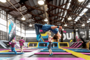 A lively group of people jumping on trampolines at an indoor trampoline park, enjoying their time together.