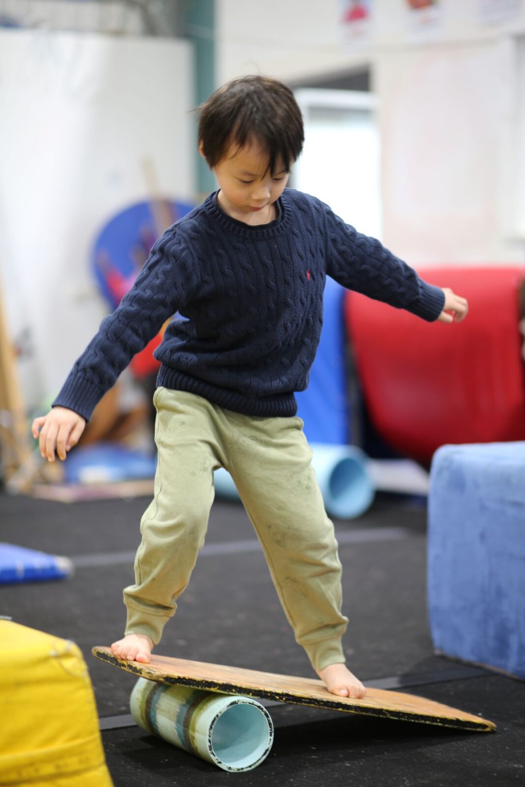 A young boy skillfully balances, showcasing his concentration and balance in an outdoor setting.
