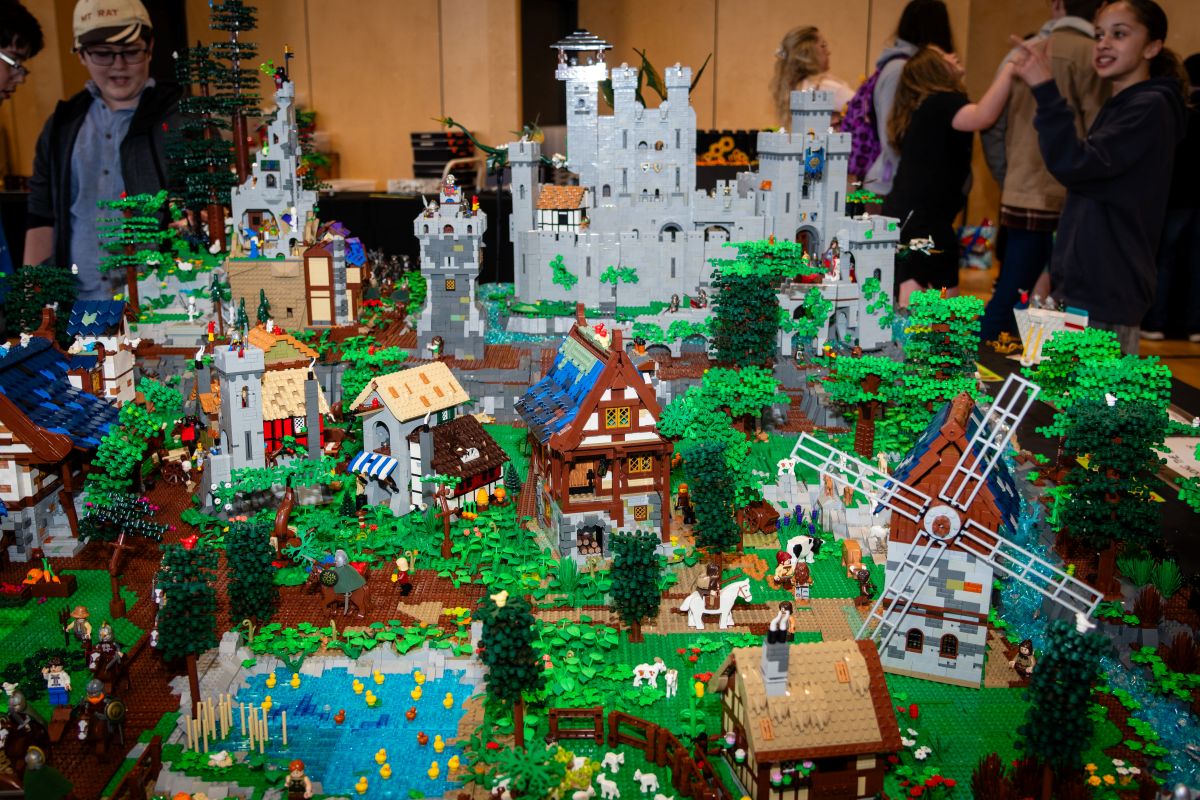 A large LEGO castle on display at a convention, showcasing intricate details and vibrant colors.