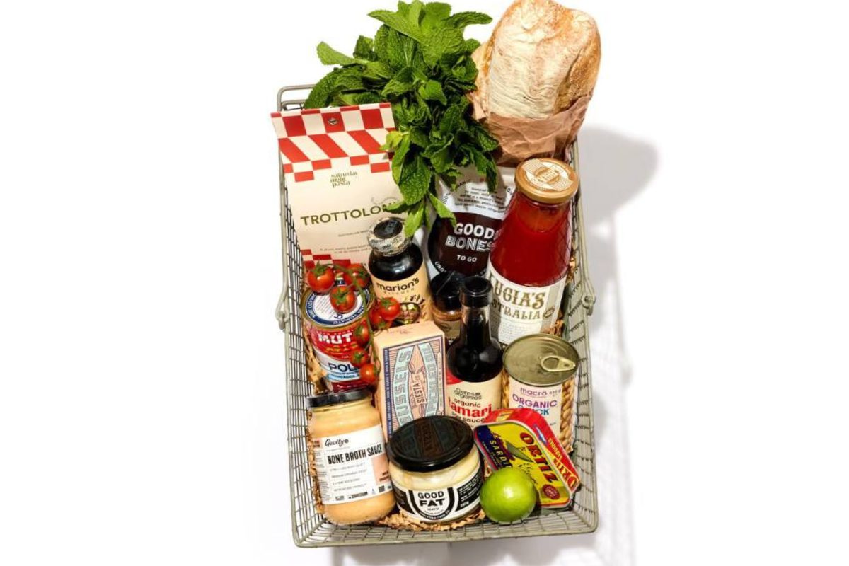 A woven basket overflowing with various food items and condiments, showcasing a colorful assortment.