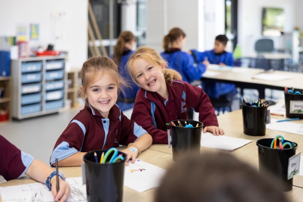 A group of children in school uniforms smiling brightly at the camera, showcasing their enthusiasm and camaraderie.
