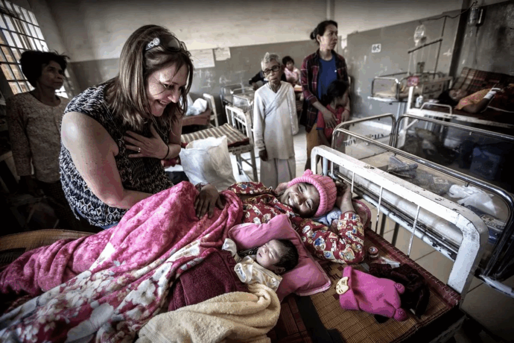A woman cradles a newborn baby in her arms while resting in a hospital bed.