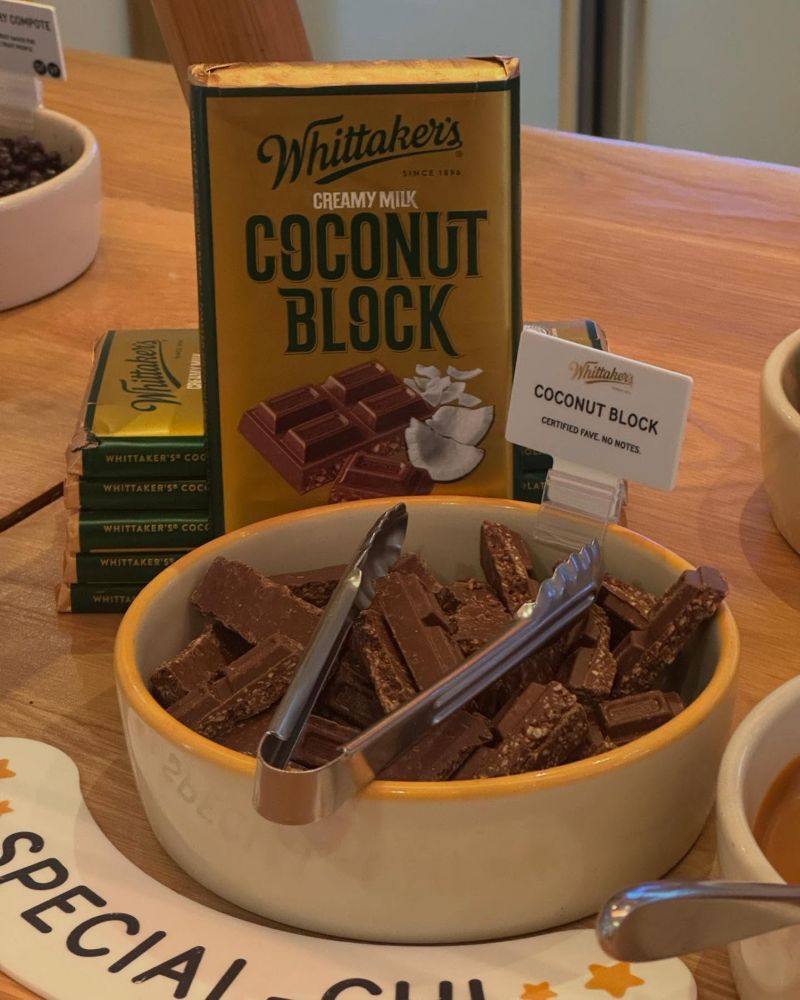 Whittaker's coconut chocolate block featuring a smooth, creamy texture and shredded coconut pieces on the packaging.
