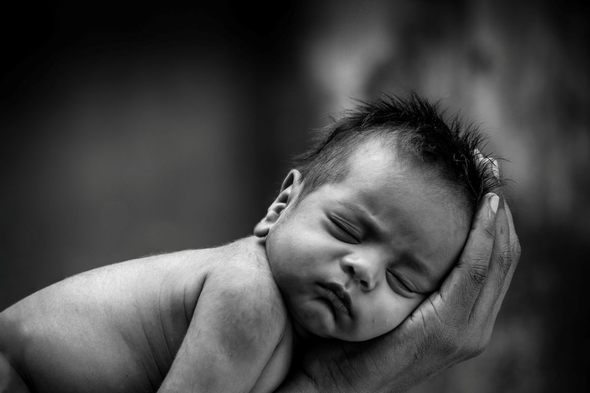 A black and white photo of a peacefully sleeping baby, showcasing their serene expression and soft features.
