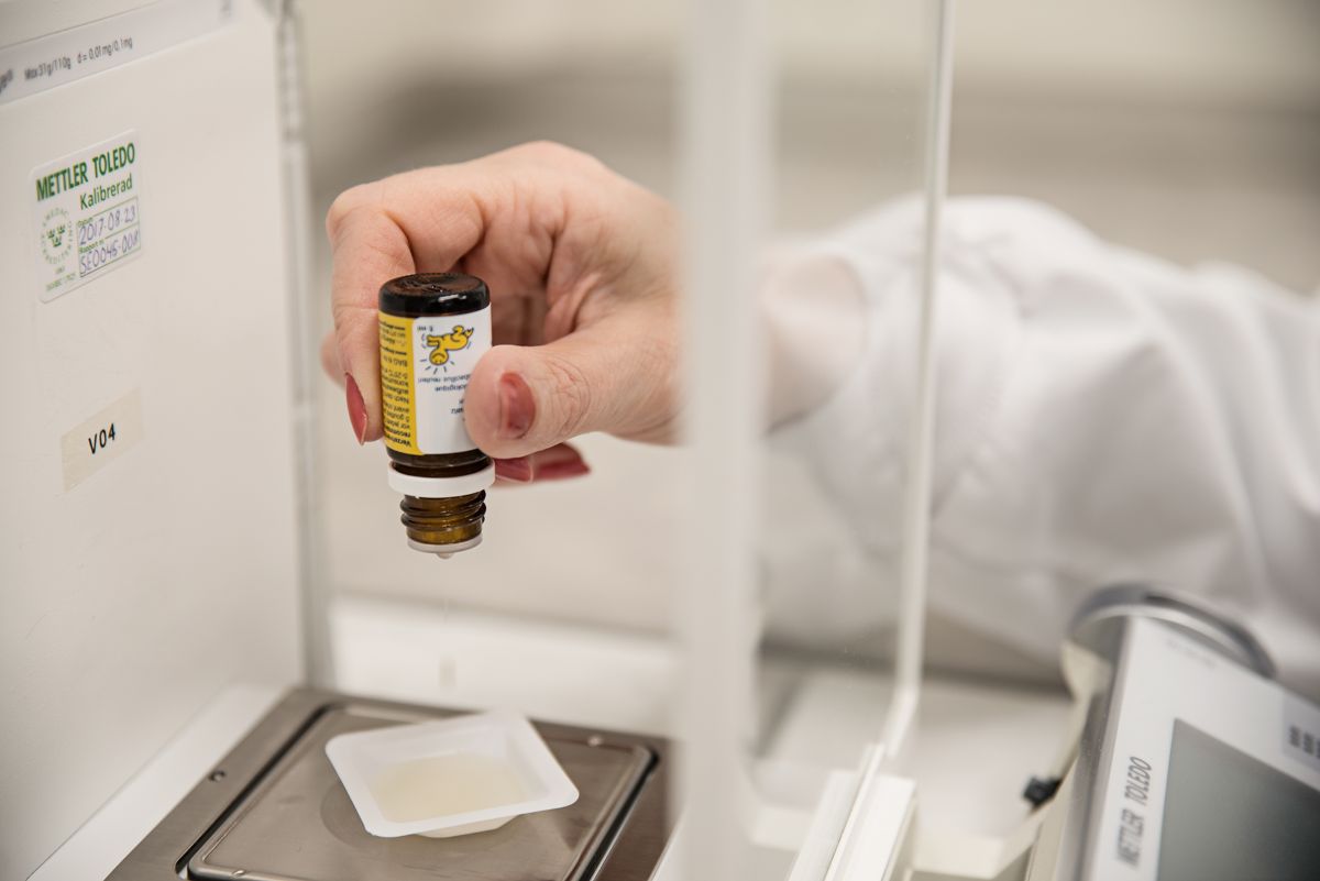 A person in a laboratory holds a bottle of liquid, preparing for an experiment or analysis.
