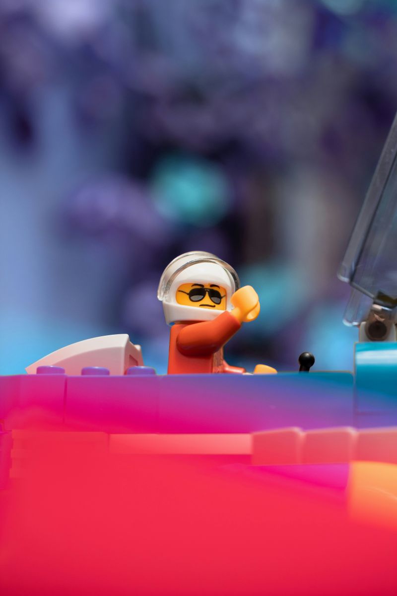  Lego figure is seated inside a colorful toy car, showcasing a playful scene.