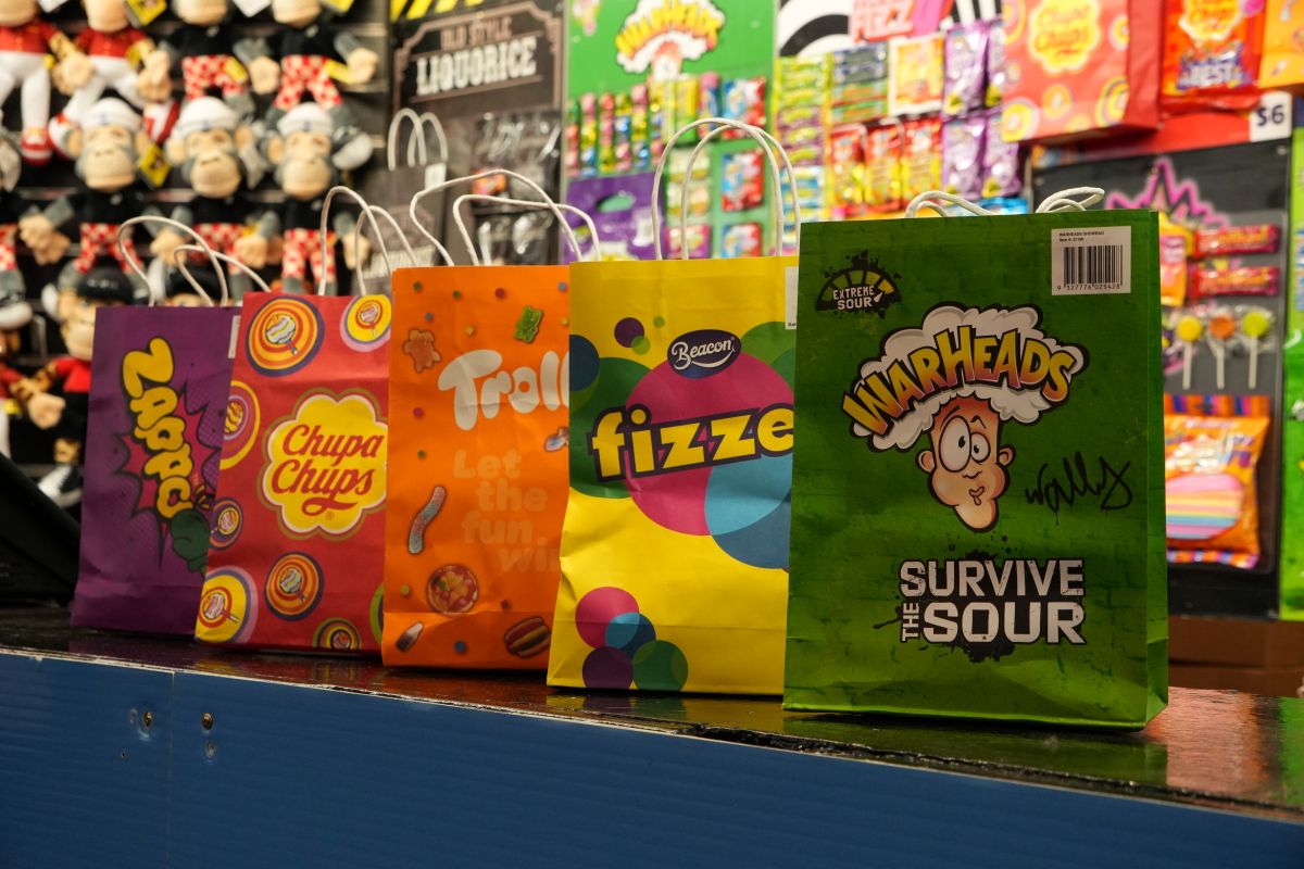 A row of vibrant bags displayed neatly on a counter, showcasing a variety of colors and styles.