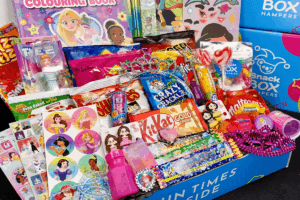 A colorful box filled with various toys and candy intended for children.