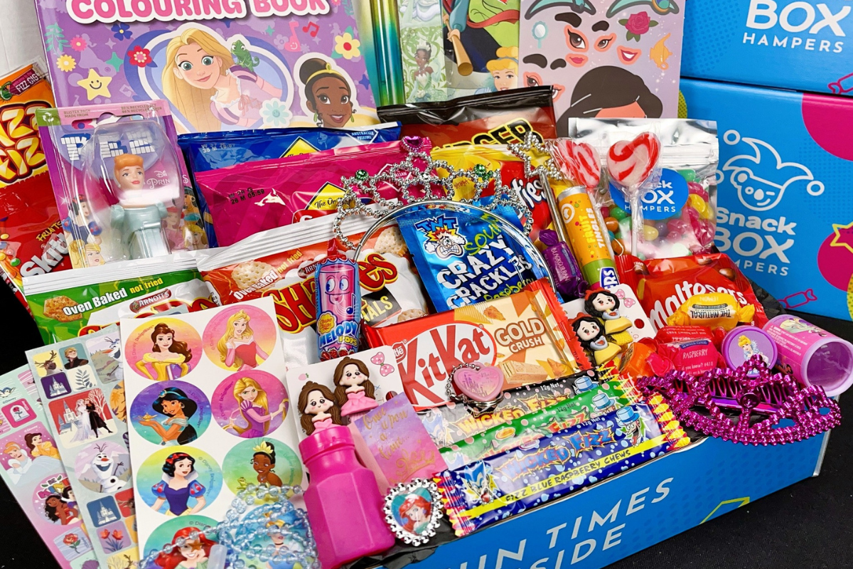 A colorful box filled with various toys and candy intended for children.