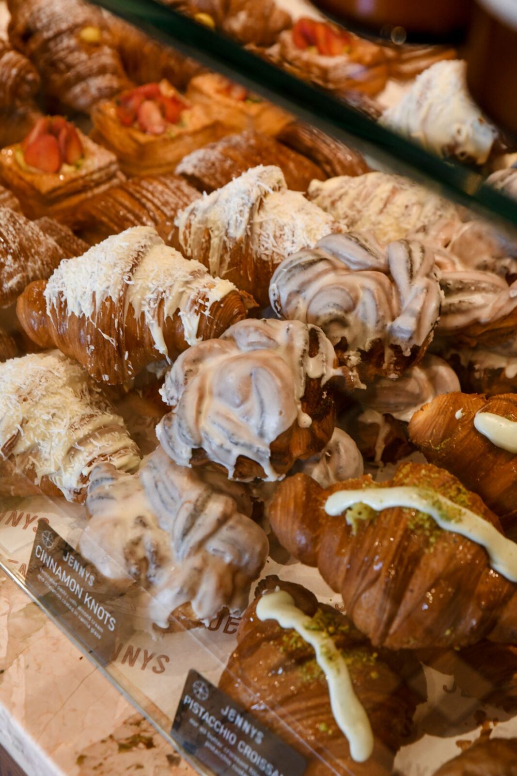  A display case filled with an assortment of colorful pastries, including cakes, tarts, and cookies.
