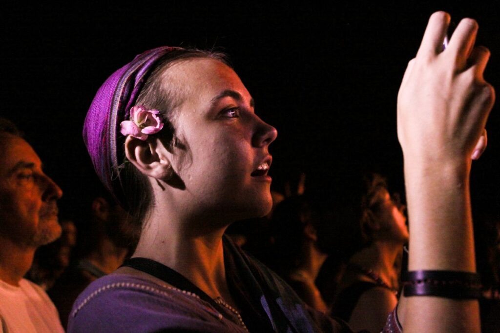 A woman holding a cell phone, looking at the screen with a focused expression.