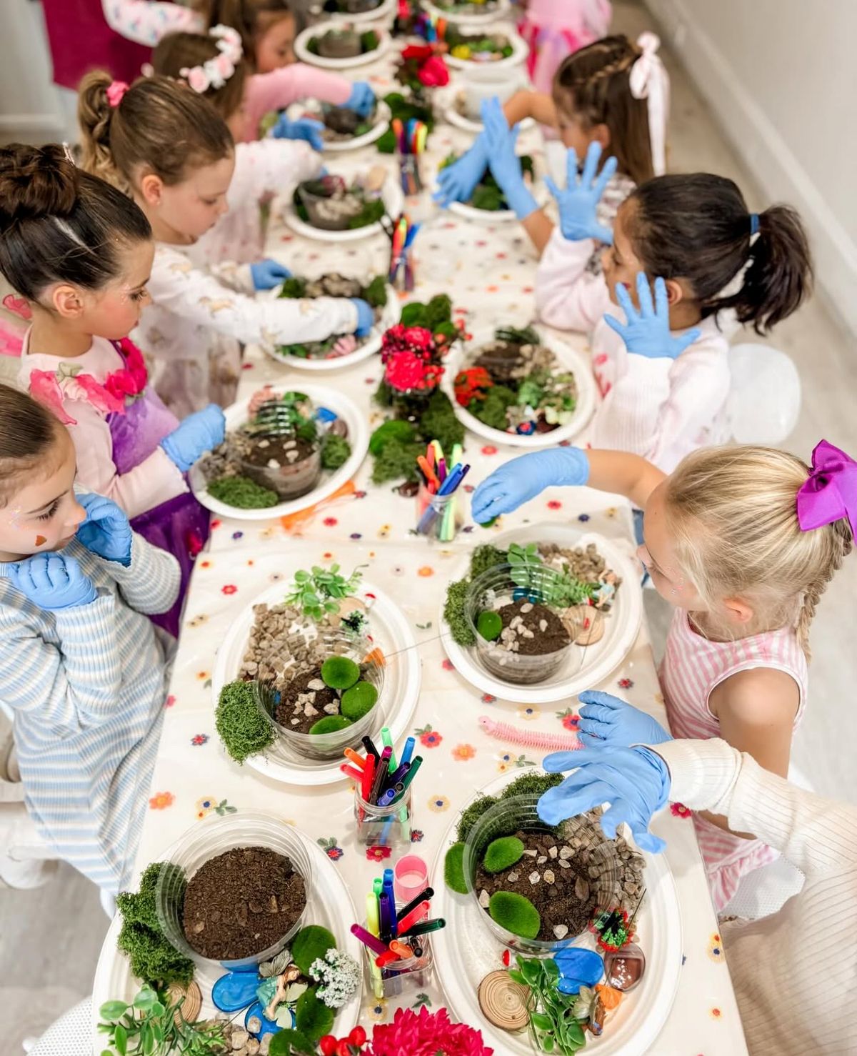 A group of children gathered around a table creating art.