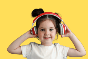 A young girl wearing headphones smiles against a bright yellow background.