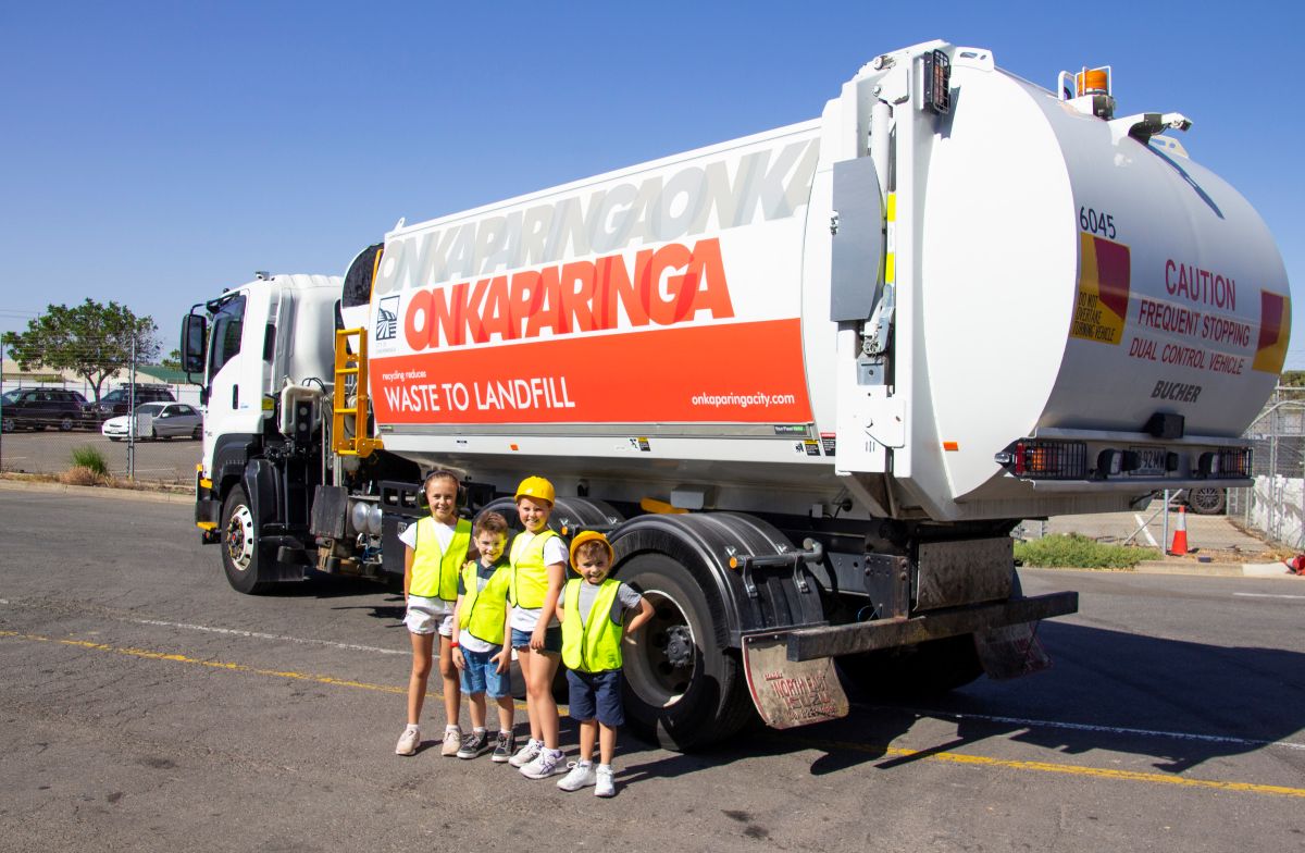 A large garbage truck parked on the street, ready for waste collection.