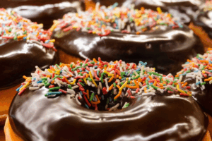 A close-up of several chocolate-covered donuts arranged together, showcasing their glossy, rich chocolate coating.