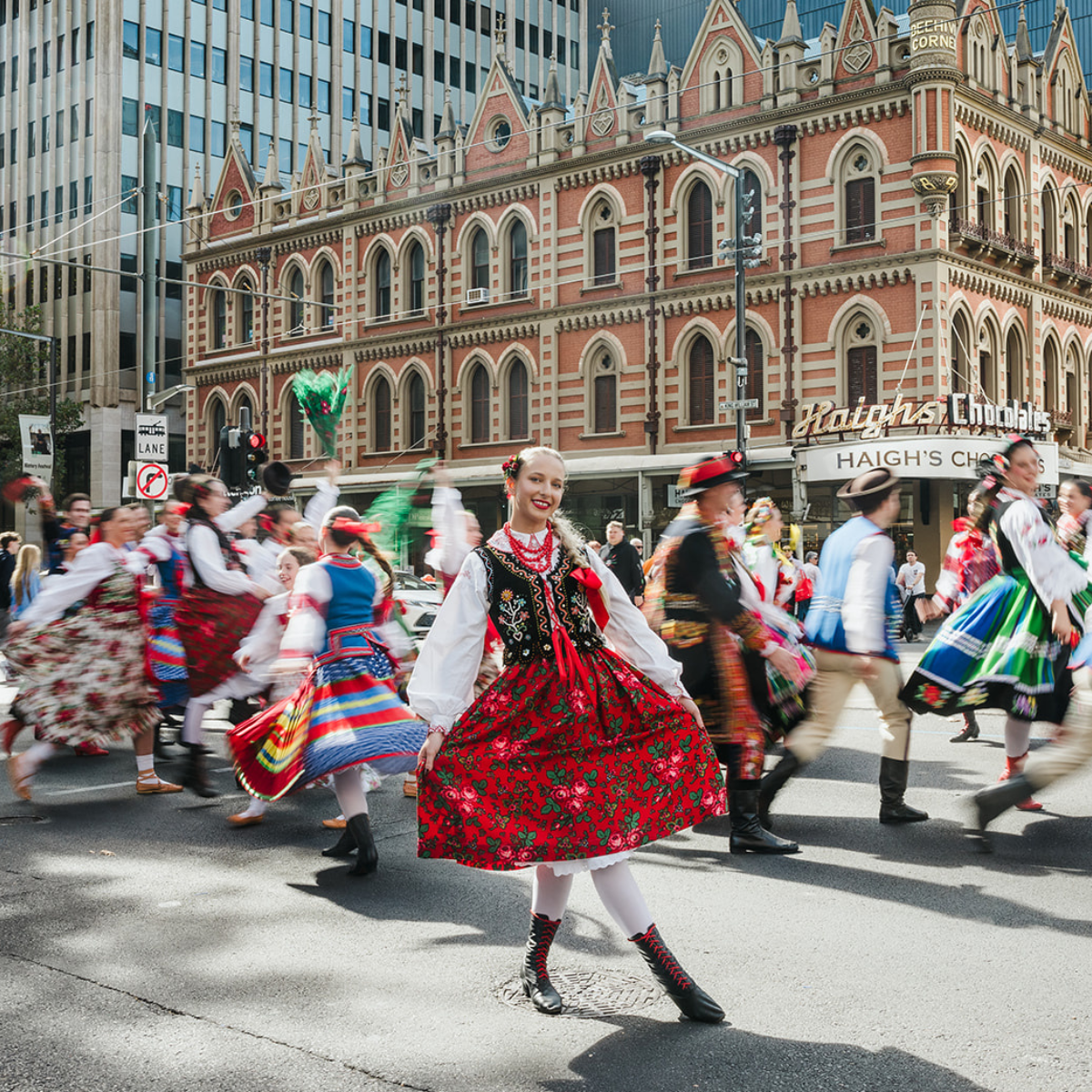 A diverse group of individuals wearing traditional clothing, showcasing various cultural styles and vibrant colors.