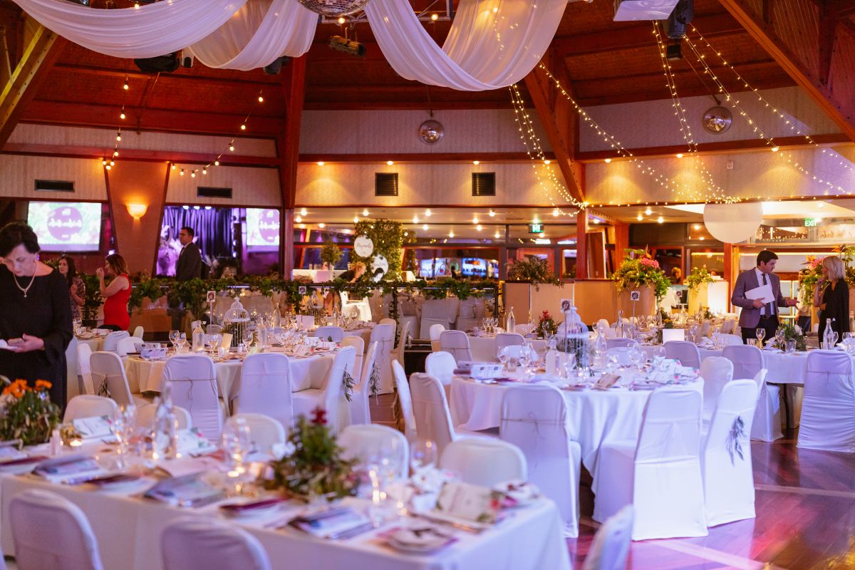 A spacious banquet hall featuring neatly arranged tables and chairs for an event or gathering.
