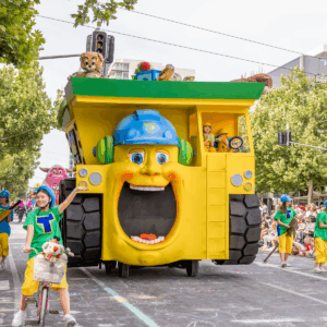 A yellow and green truck parked on a street, showcasing its vibrant colors and sturdy design.