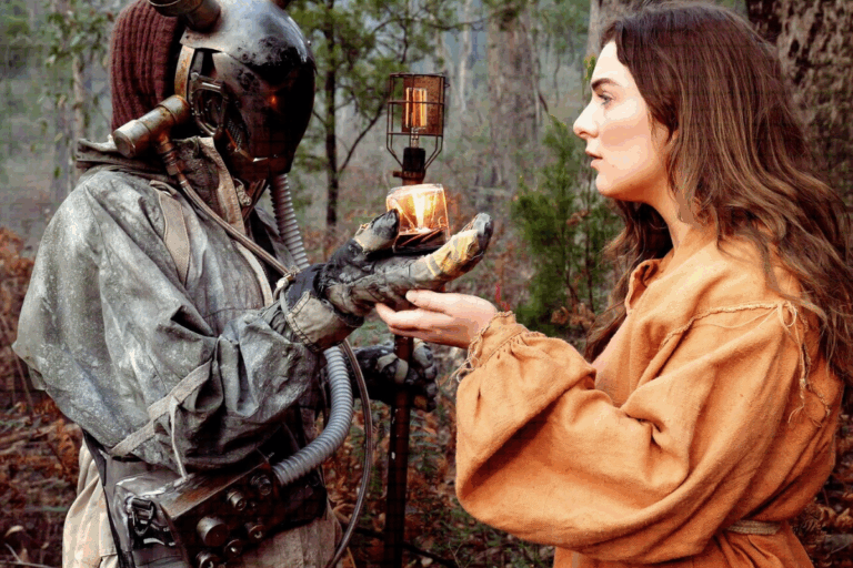 A woman in a costume holds a candle beside a man in a costume, both posing for a photo in a festive setting.