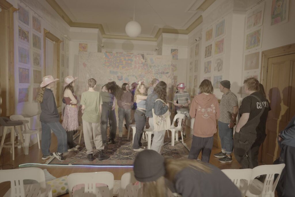 A group of people standing together in a room, engaged in conversation and interacting with one another.